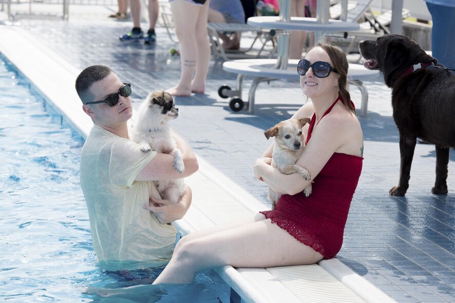 Staff Sgt. Michael Kelly, 374th Airlift Wing equal opportunity advisor, and his wife relax with their dogs in the pool during the Dog Days of Summer event at Yokota Air Base, Japan, Sept. 9, 2017.
