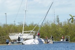 Teams with the Florida National Guard’s Chemical Biological Radiological Nuclear Emergency Response Force-Package and the Florida Fish and Wildlife Conservation Commission search a demolished sailboat.