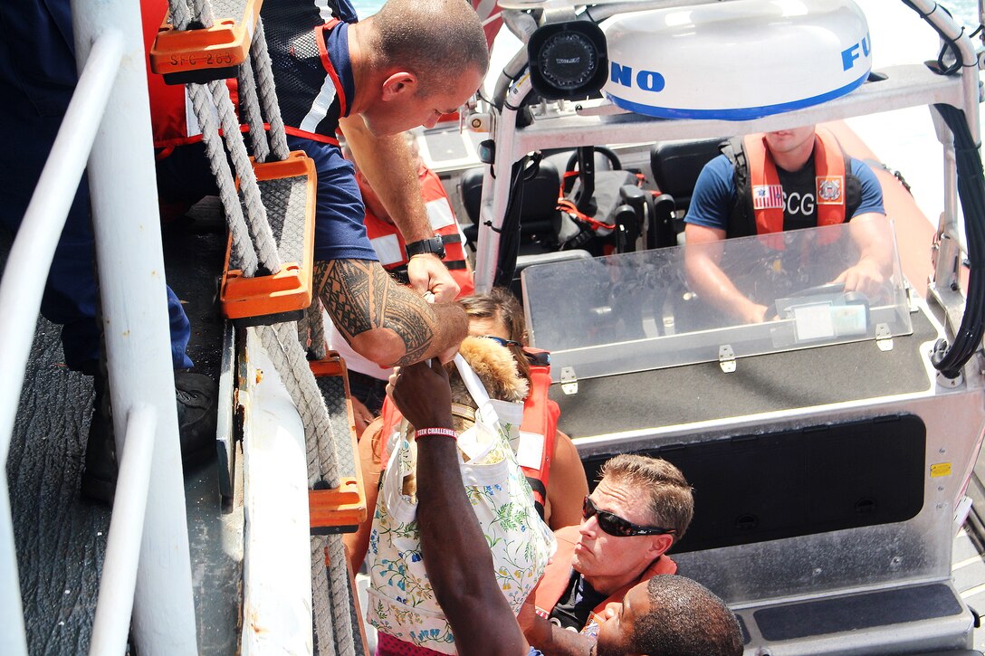 Coast Guard members help families and a dog.