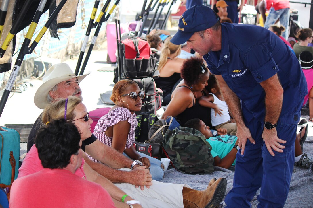 A Coast Guard commander talks with hurricane victims.