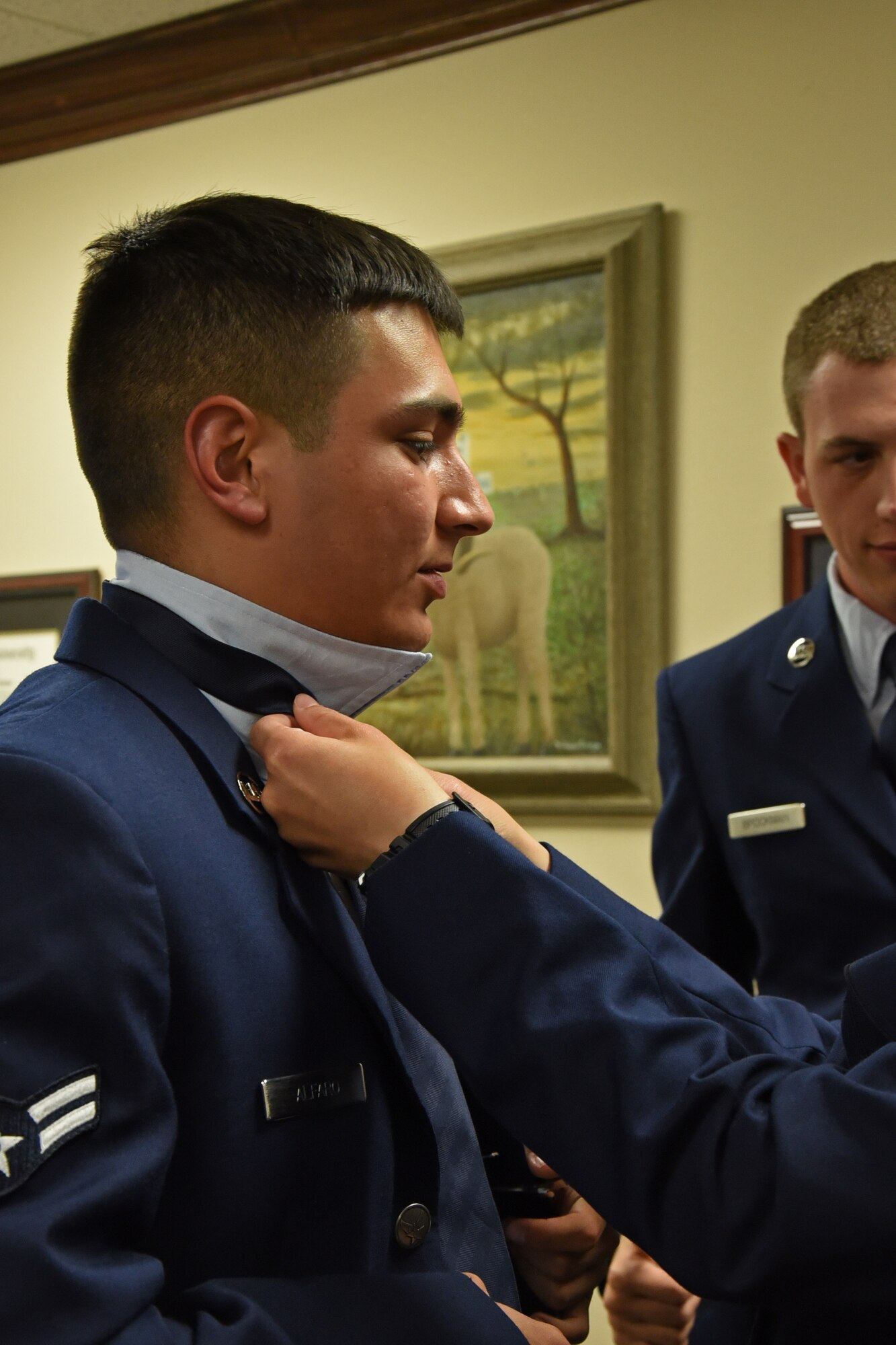 U.S. Air Force Airman 1st Class Syrus Alfaro, 315th Training Squadron student, one of 50 student volunteers, has his tie fixed while preparing for the Military Appreciation Day at Angelo State University’s LeGrande Stadium in San Angelo, Texas, Sept. 9, 2017. Alfaro and the other volunteers held flags from each U.S. state during the Oath of Enlistment during the halftime ceremony.  (U.S. Air Force photo by Airman Zachary Chapman/Released)