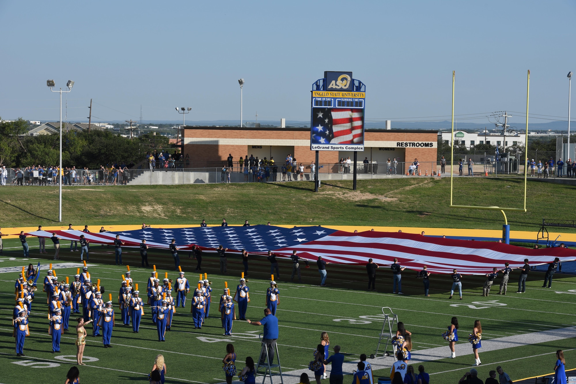 Angelo State University ROTC students unfold the American flag during the opening ceremonies of the Military Appreciation Day at LeGrand Stadium in San Angelo, Texas, Sept. 9, 2017. Along with the ceremonial unfolding of the flag the ROTC students also celebrated each touchdown with a run to the end zone and pushups. (U.S. Air Force photo by Airman Zachary Chapman/Released)