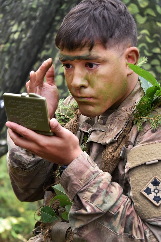 A soldier applies camouflage face paint before participating in the Expert Infantryman Badge competition.