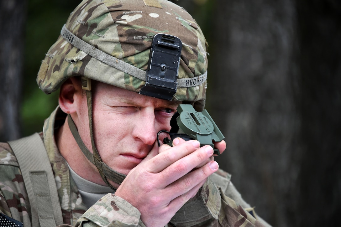 A soldier practices with a lensatic compass before participating in the Expert Infantryman Badge competition.