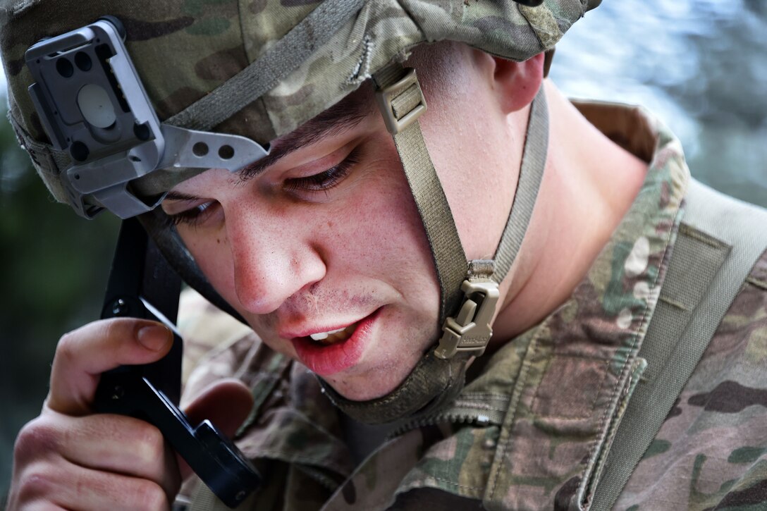 A soldier talks on the radio during the Expert Infantryman Badge competition.