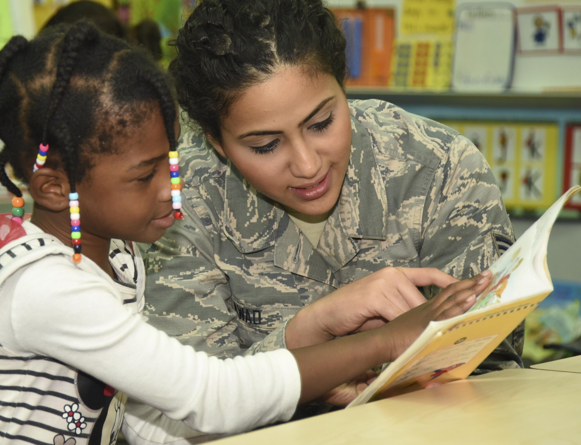 Senior Airman Sandra Awad, 301st Medical Squadron surgical technician, interacts with a special needs student while reading a book together Aug.23, 2017, at Lone Star Elementary School in Keller, Texas. Eight Reserve medical Airmen visited the school to connect and read to students as part their unit's community outreach program. (U.S. Air Force photo by Ms. Julie Briden-Garcia)