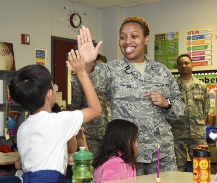 Capt. Carolyn Joe, 301st Medical Squadron officer, high-fives a Lone Star Elementary School student after he answers a question from 301 MDS Airmen during a visit Aug. 23, 2017, to the school in Keller, Texas. Eight Reserve medical Airmen visited the students as part their unit's community outreach program. (U.S. Air Force photo by Ms. Julie Briden-Garcia)