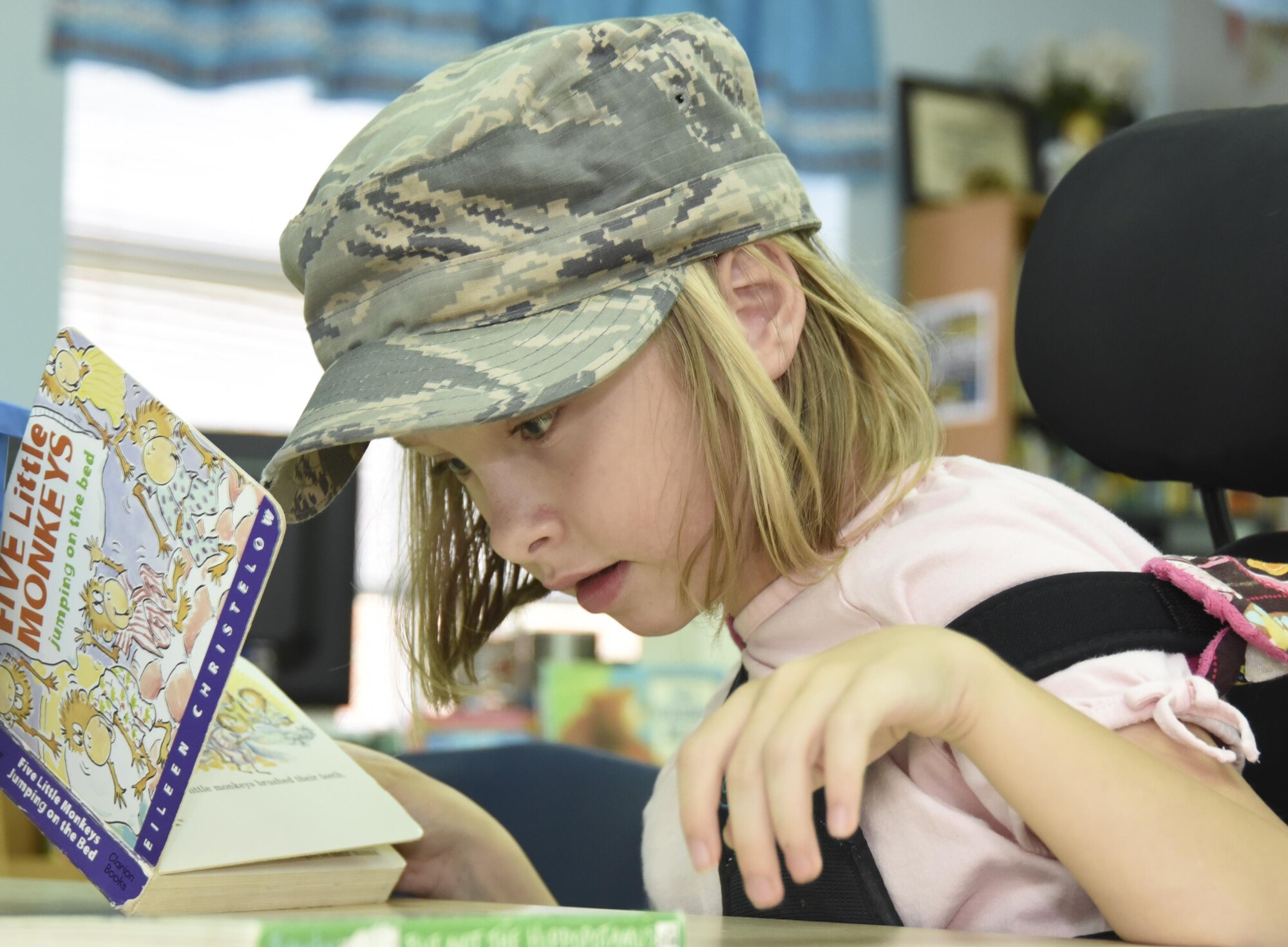 A Lone Star Elementary School student shares 301st Medical Squadron Master Sgt. Nate McReynolds’ military cap while they read together during a visit Aug. 23, 2017, in Keller, Texas. Eight Reserve medical Airmen visited the school to connect and read to students as part their unit's community outreach program. (U.S. Air Force photo by Ms. Julie Briden-Garcia)