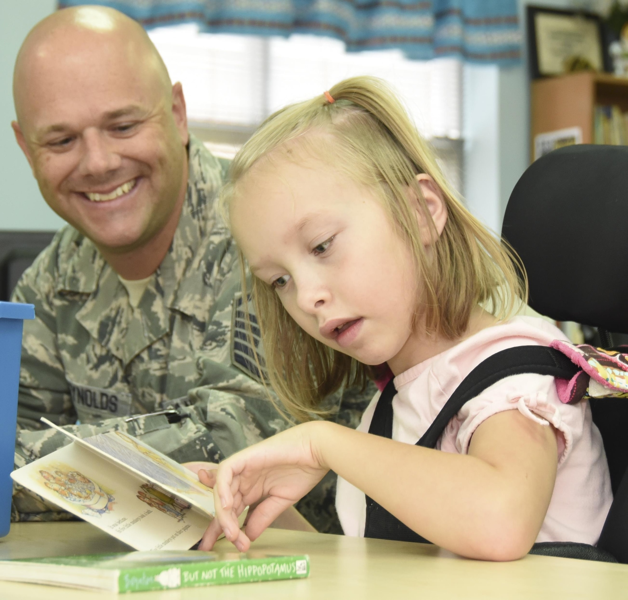 Master Sgt. Nate McReynolds, 301st Medical Squadron surgical technician, reads to a student and neighbor Aug. 23, 2017, at Lone Star Elementary School in Keller, Texas. Eight Reserve medical Airmen visited the school to connect and read to students as part their unit's community outreach program. (U.S. Air Force photo by Ms. Julie Briden-Garcia)