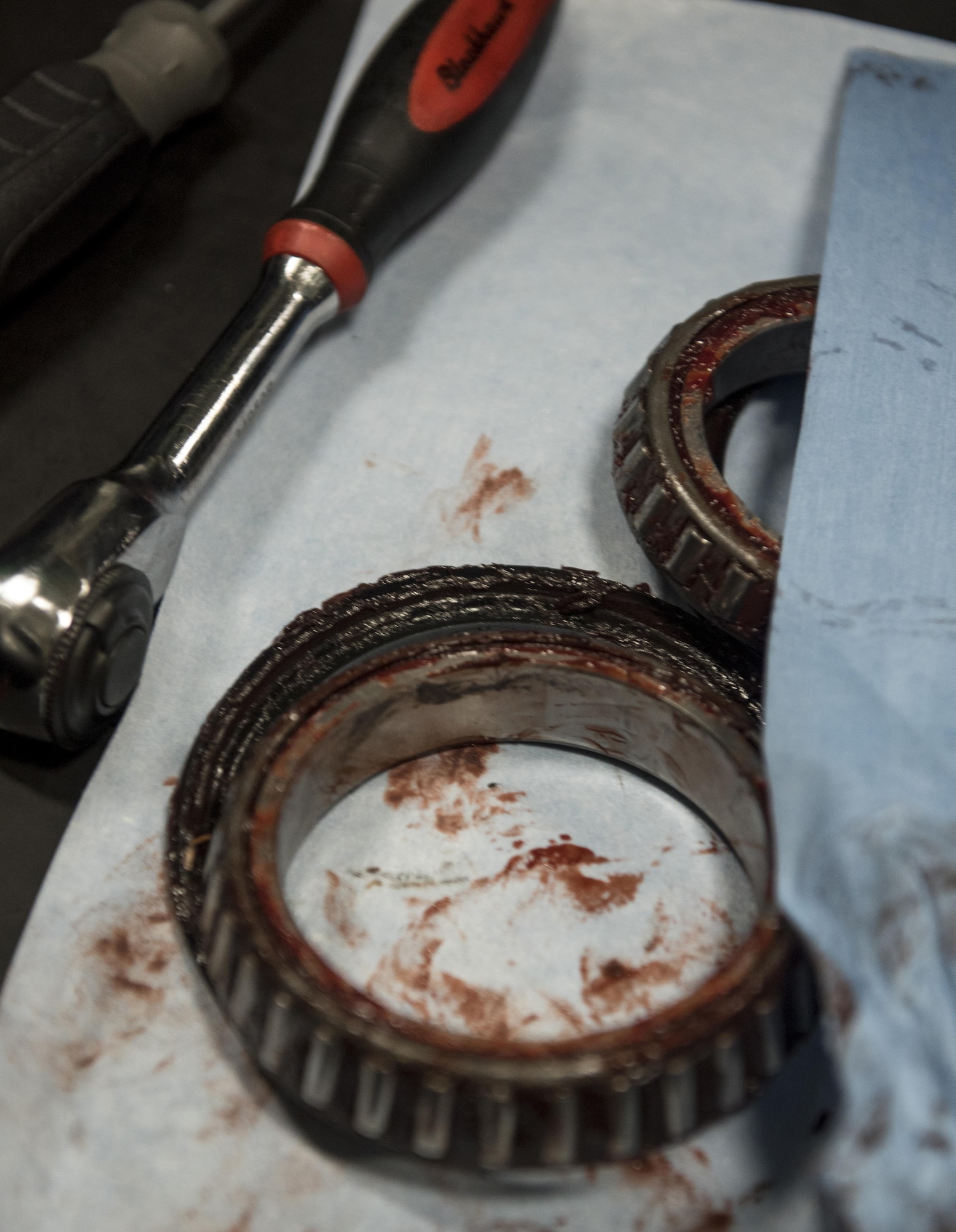 Air Force wheel and tire shop technicians assigned to the 33rd Maintenance Squadron and aviation structural mechanics assigned to USS Abraham Lincoln (CVN 72) remove wheel bearings from an F-35C Lightning II wheel Sept. 6, 2017, aboard the ship. Two Airmen and two Sailors from 33rd MXS qualified Abraham Lincoln Sailors to operate F-35 support equipment bringing the U.S. Navy one step closer to initial operations capability. (U.S. Air Force photo by Staff Sgt. Peter Thompson/Released)