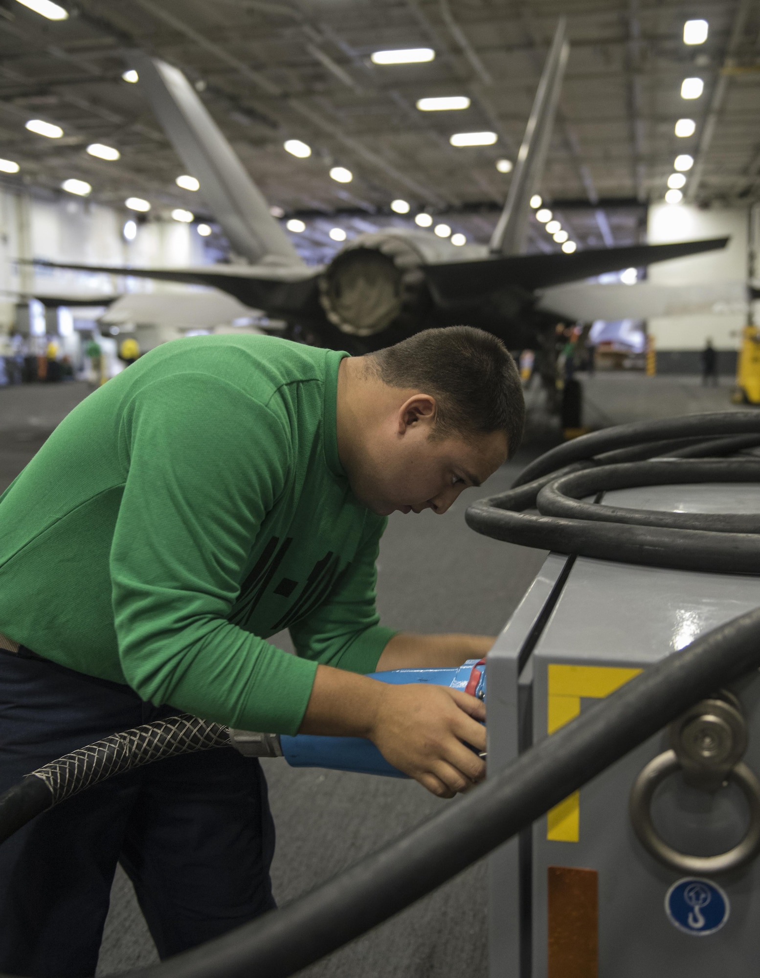 U.S. Air Force Airman 1st Class Elizandro Chapa, 33rd Maintenance Squadron aerospace ground equipment journeyman, connects a cable to a ground power cart Sept. 6, 2017, aboard the Nimitz-class aircraft carrier USS Abraham Lincoln (CVN 72). Two Airmen and two Sailors from 33rd MXS qualified Abraham Lincoln Sailors to operate F-35 support equipment bringing the U.S. Navy one step closer to initial operations capability. (U.S. Air Force photo by Staff Sgt. Peter Thompson/Released)