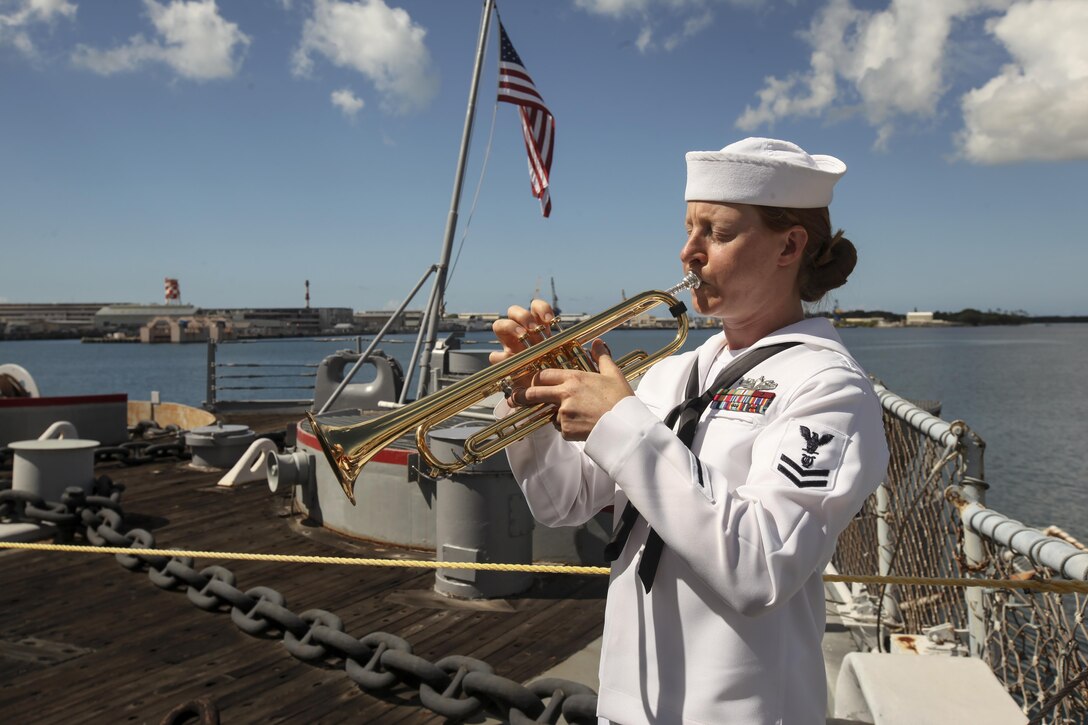 A musician with the U.S. Pacific Fleet Band plays Taps during the 72nd Anniversary of the End of World War II ceremony aboard the USS Battleship Missouri Memorial, Pearl Harbor, Hawaii, September 2, 2017. The ceremony on the aft deck was attended by dignitaries from the United States and other nations. Today, the U.S. and Japan stand together, showcasing an alliance of peace forged between our two nations. (U.S. Marine Corps photo by Cpl. Maximiliano Rosas)
