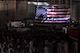 Attendees of the 9/11 Memorial watch a tribute video projected onto a flag at the  Louis F. Garland Department of Defense Fire Academy high bay on Goodfellow Air Force Base, Texas, Sept. 11, 2017. The video showed footage of the towers falling and paid tribute to all the first responders who died on 9/11. (U.S. Air Force photo by Airman Zachary Chapman/Released)