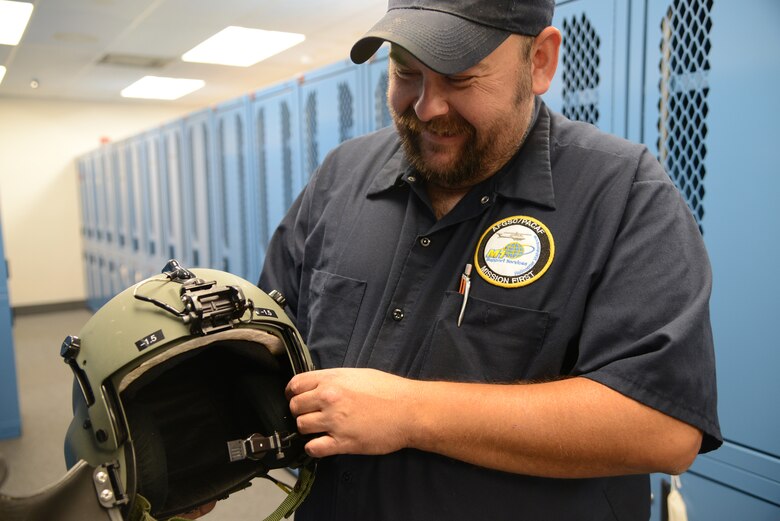 Sean Baker, aircrew flight equipment mechanic for M1 support services at the 40th Helicopter Squadron, shows one of the helmets he maintains and inspects Sept. 12, 2017, at Malmstrom Air Force Base, Mont.