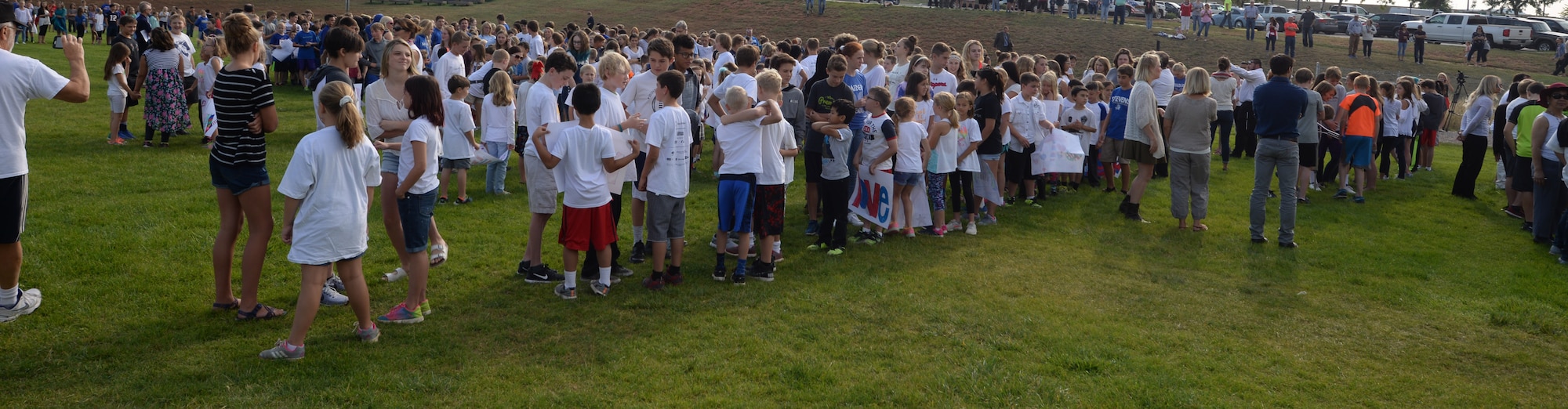 Students from Southwest Middle School and Corral Drive Elementary gather on the middle school’s football field before Patriot’s Day events in Rapid City S.D., Sept. 11, 2017. The students participated in the event, recited the Pledge of Allegiance, walked in a parade, and thanked local first responders and service members. (U.S. Air Force Photo by Airman 1st Class Thomas Karol)