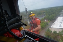 Petty Officer 2nd Class Graham McGinnis, an aviation survival technician, responds to a rescue request in Houston, Aug. 27, 2017. The Coast Guard partners with local Emergency Operations Centers and established an Incident Command Post to manage search and rescue operations. U.S. Coast Guard courtesy photo by Petty Officer 2nd Class Bob Hovey