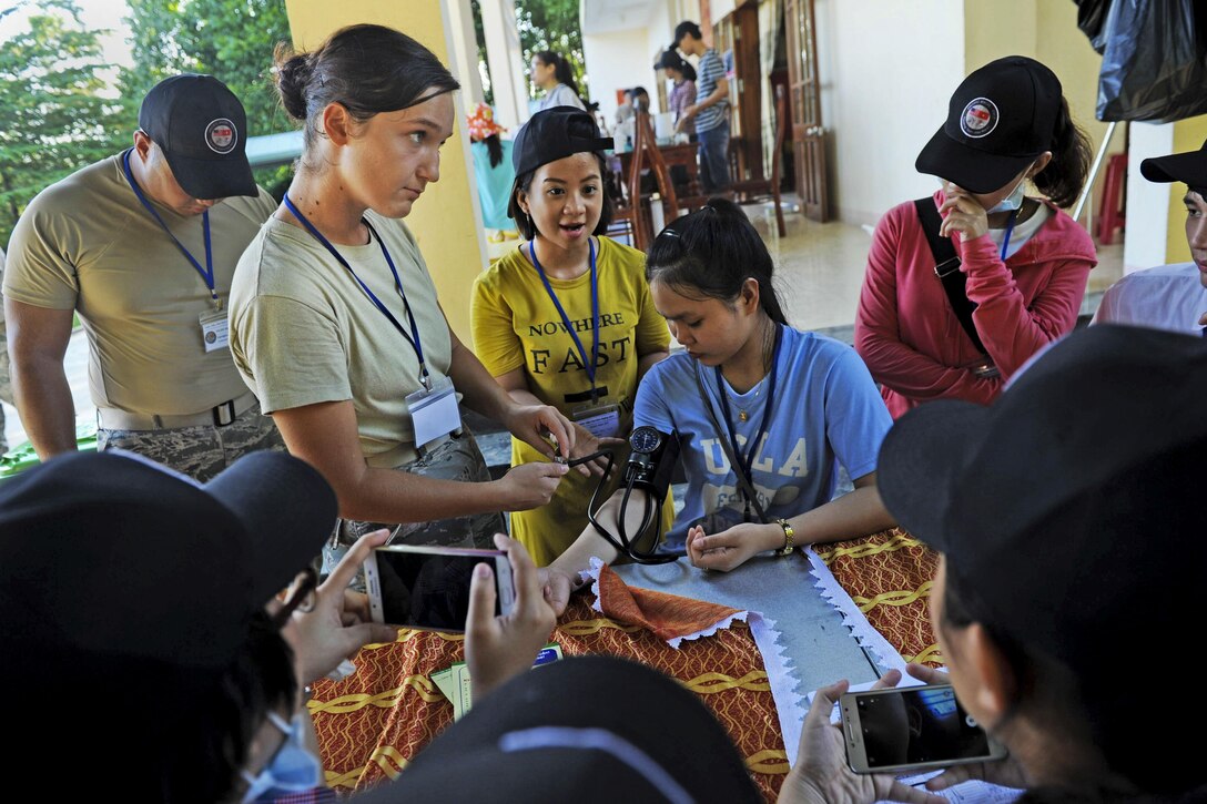 An airman takes a student's blood pressure as others observe.