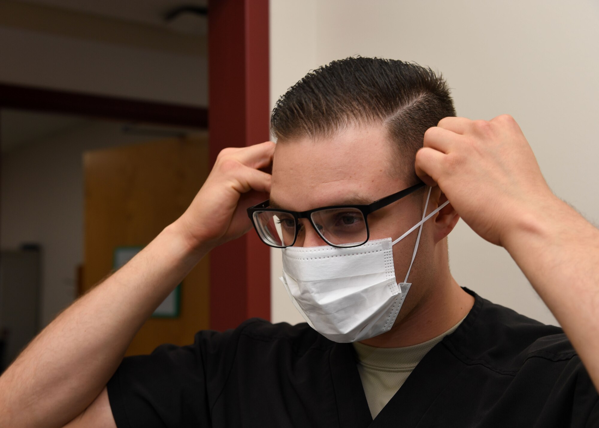 Senior Airman Alexis Lopez, dental assistant with the 319th Medical Group, demonstrates proper sanitary procedure by putting on a face mask at the medical treatment facility on Grand Forks Air Force Base, North Dakota, Sept. 7, 2017. Lopez said in addition to personal sanitation, there are also multiple steps taken to ensure treatment rooms are sanitary and prepared for patient use. (U.S. Air Force photo by Airman 1st Class Elora J. Martinez)
