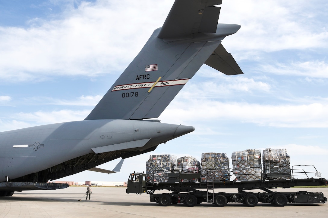 Airmen prepare to load palletized cargo onto a C-17A Globemaster III.