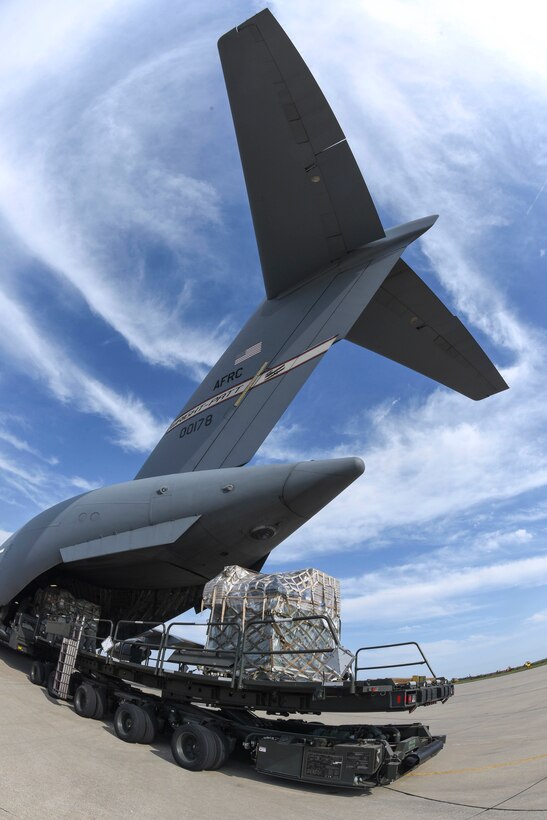 Airmen position palletized cargo bound for Florida at the loading ramp of a C-17A Globemaster III