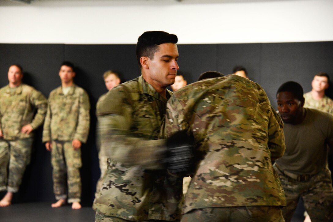 Staff Sgt. Robert Ward, right, observes his students conducting punching drills during a basic combatives course