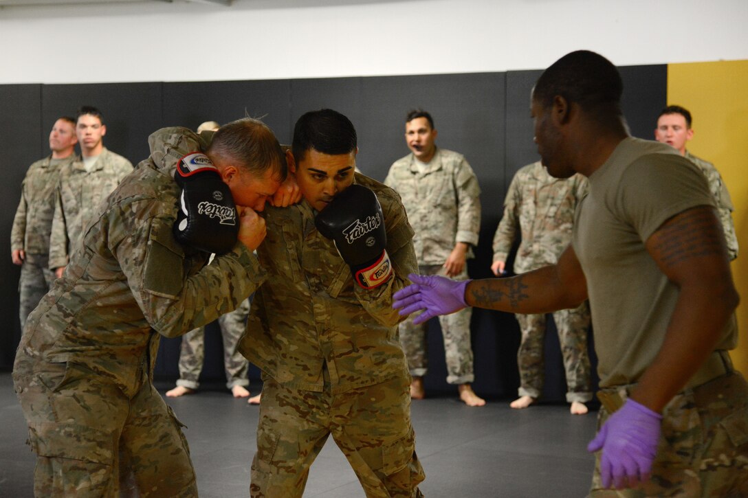 Staff Sgt. Robert Ward, right, prepares his students to conduct punching drills during a basic combatives course.
