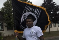 U.S. Air Force Staff Sgt. Courtland Little, 435th Security Forces Squadron resource advisor, holds the POW/MIA guidon for the Tri-Wing POW/MIA Memorial Run on Ramstein Air Base, Germany, Sept. 13, 2017. Little coordinated this year’s memorial run, garnering approximately 1,200 participants for the run in honor of prisoners of war and missing in action service members. (U.S. Air Force photo by Senior Airman Tryphena Mayhugh)