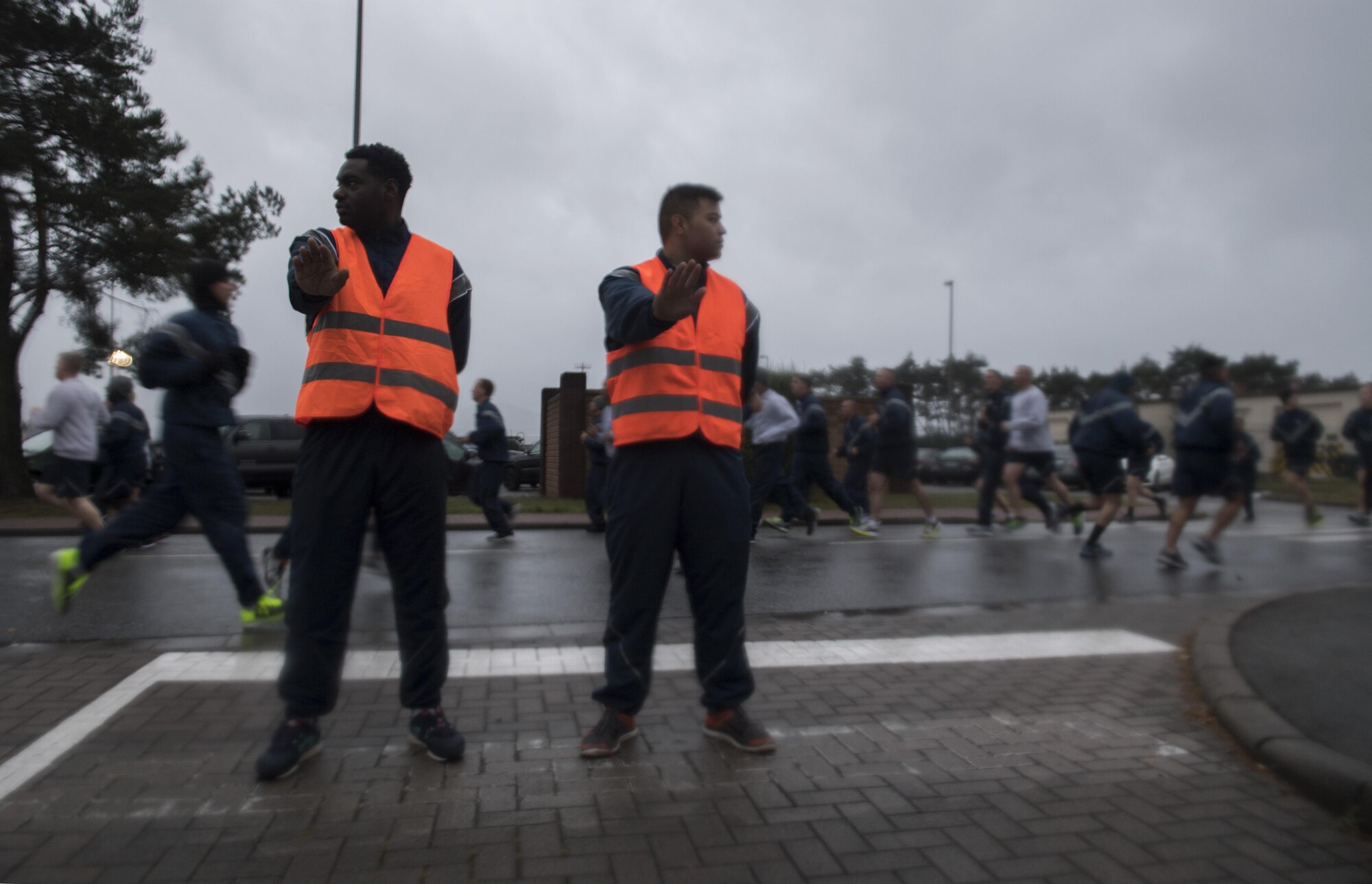 U.S. Air Force Senior Airman Brandon Smith (left) and Airman 1st Class Mark Ames, both 86th Logistic Readiness Squadron traffic management office apprentices, prevent traffic from entering the road during the Tri-Wing POW/MIA Memorial Run on Ramstein Air Base, Germany, Sept. 13, 2017. Approximately 1,200 Airmen assigned to the 86th Airlift Wing, 521st Air Mobility Operations Wing, and 435th Air Ground Operations Wing participated in the run honoring those who were or are prisoners of war or missing in action. (U.S. Air Force photo by Senior Airman Tryphena Mayhugh)