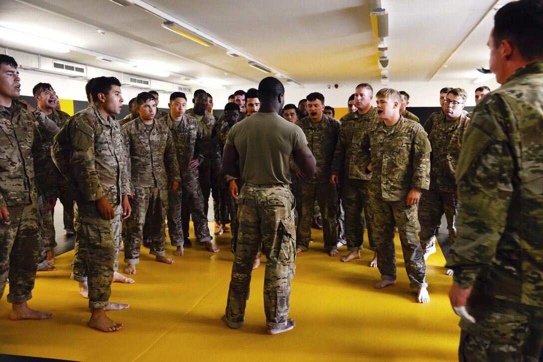 Staff Sgt. Robert Ward, middle, briefs his students before they conduct punching drills during a basic combatives course