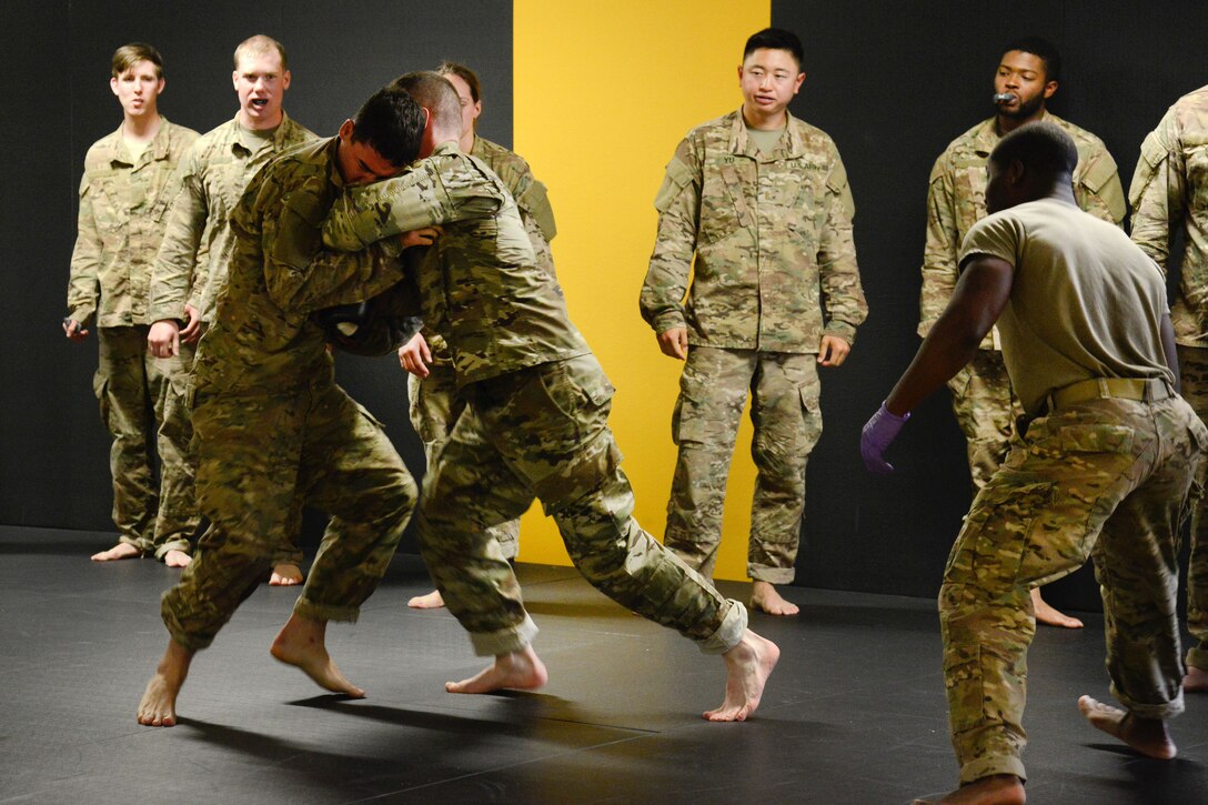 Staff Sgt. Robert Ward, right, observes his students conduct punching drills during a basic combatives course