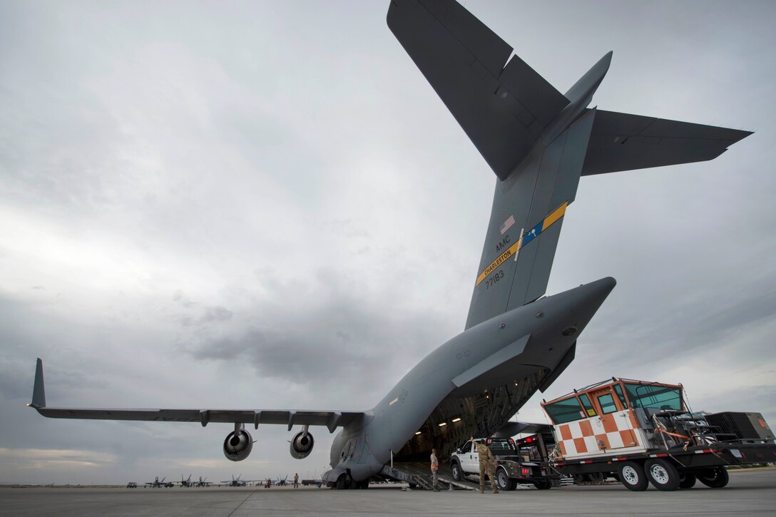 Airmen load a mobile traffic control tower system onto a C-17 Globemaster III
