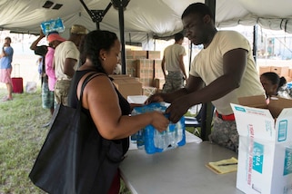 Residents receive food and water from Virgin Islands Army National Guardsmen in St. John, Virgin Islands