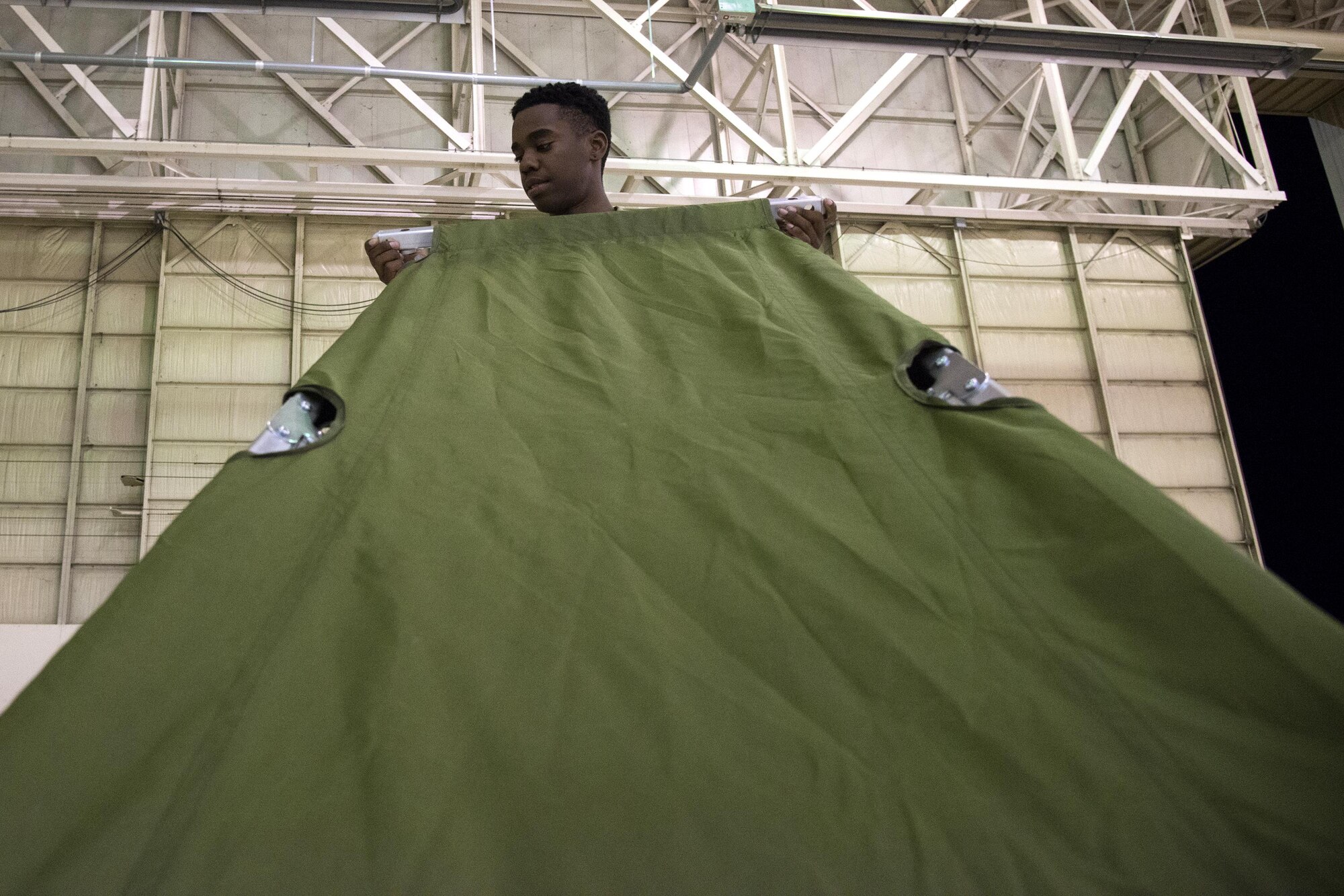 U.S. Army Pfc. Christopher Freeman, Georgia Army National Guard 781st Joint Task Force Chemical, Radiological, Nuclear, Explosive Response Package chemical specialist, assembles his cot, Sept. 12, 2017, at Moody Air Force Base, Ga. Units from the 48th Infantry Brigade Combat Team and JTF 781st CERFP stayed the night at Moody before heading to Orlando, Fla., to provide humanitarian relief for the victims of Hurricane Irma. (U.S. Air Force photo by Airman 1st Class Erick Requadt)