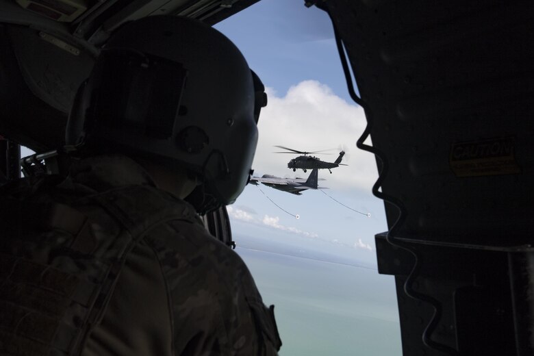 Staff Sgt. Nathan Franklin, 66th Rescue Squadron special missions aviator, watches another HH-60G Pave Hawk prior to a helicopter air-to-air refueling, Sept. 12, 2017, over the skies of Florida. The 563d Rescue Group prepositioned aircraft and personnel for rescue operations in support of FEMA and U.S. Northern Command after Hurricane Irma made landfall in Florida. (U.S. Air Force photo by Tech. Sgt. Zachary Wolf)
