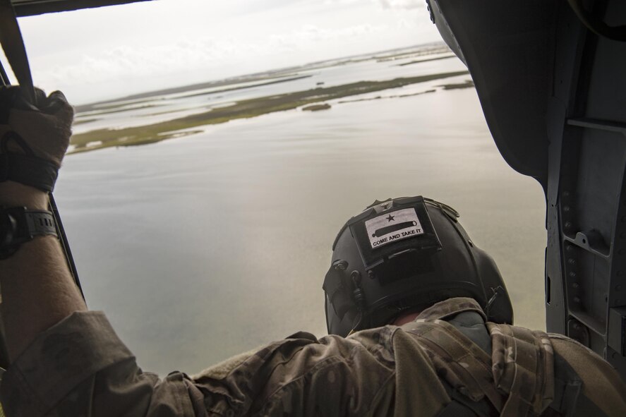 Staff. Sgt. Josh Burrow, 66th Rescue Squadron special missions aviator, scans the ground from an HH-60G Pave Hawk, Sept. 12, 2017, in the skies over South Florida. The 563d Rescue Group prepositioned aircraft and personnel in support of FEMA and U.S. Northern Command for rescue operations after Hurricane Irma made landfall in Florida. (U.S. Air Force photo by Staff Sgt. Ryan Callaghan)