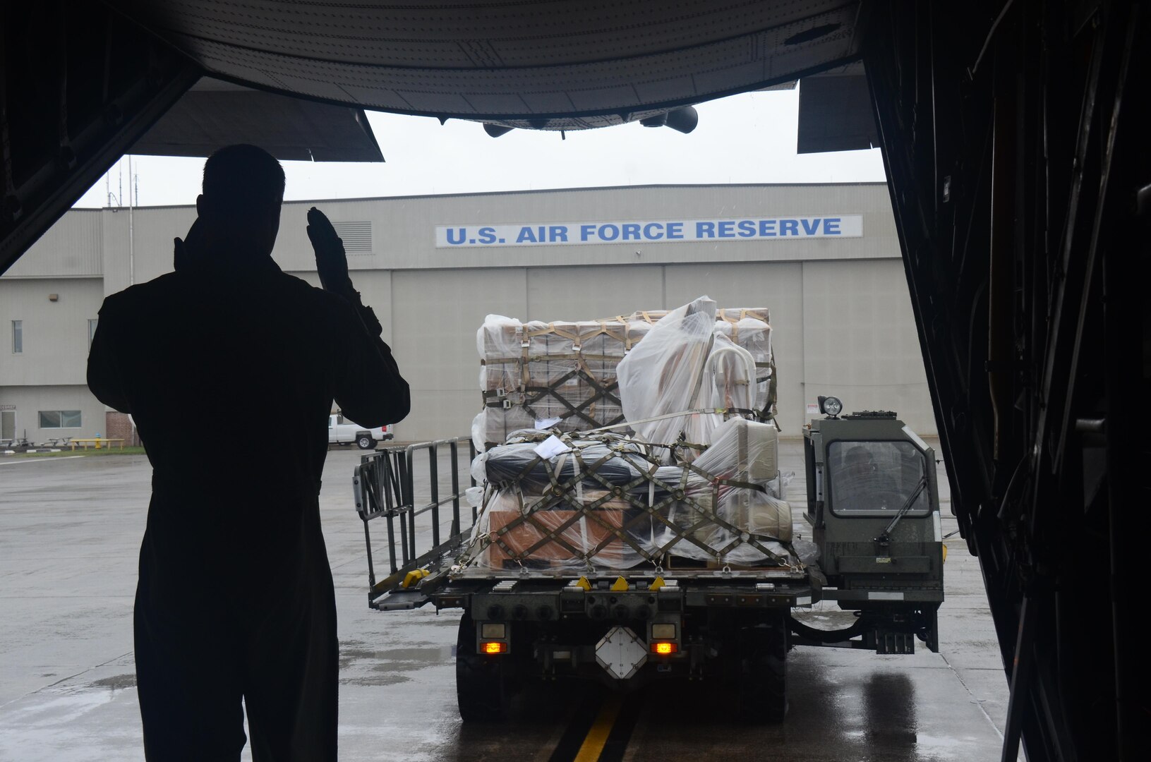 An Airman guides in cargo from the back of a C-130H3 Hercules at Dobbins Air Reserve Base, Ga. Sept. 12, 2017. 94th Airlift Wing C-130s and aircrews provided airlift support as part of the Air Force Reserve’s relief efforts following Hurricane Irma. (U.S. Air Force photo/Don Peek)