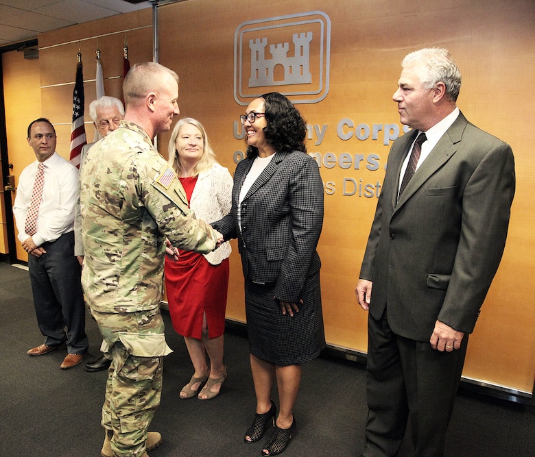 Col. Kirk Gibbs, commander of the U.S. Army Corps of Engineers Los Angeles District, center left, congratulates LaShawn Richardson, realty specialist and contracting officer representative with the District’s Asset Management Division, second from right, for her hard work as a member of the negotiating team during a Sept. 12 labor-management agreement signing ceremony at the District’s office in downtown LA. Gibbs presented District coins to all members of the team who spent about 18 hours a week during the past five months working on the agreement.