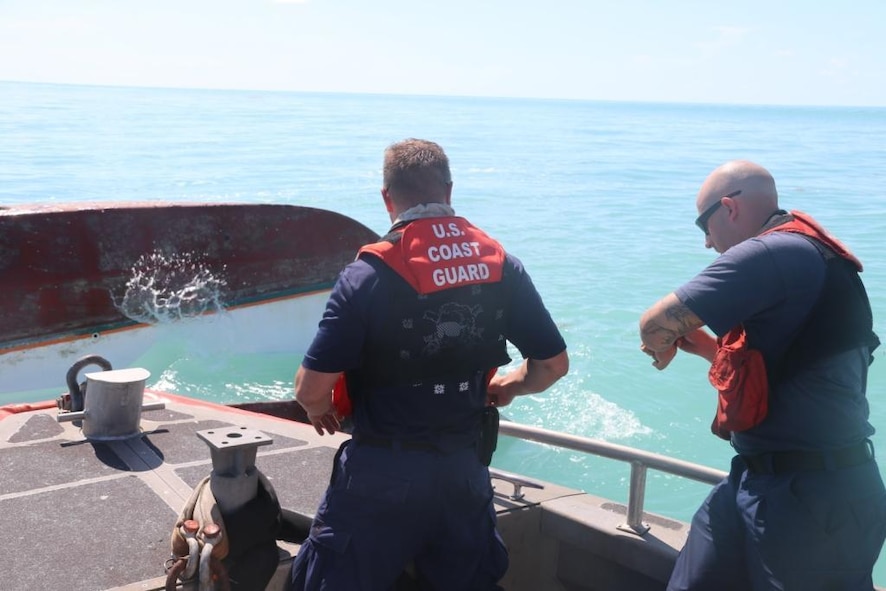 A 35-foot long range interceptor crewmember writes down an overturned vessel's registration number found off the coast of Key West, Florida, Sept. 13, 2017. Coast Guard Cutter Hamilton's crew was deployed to Florida in support of Hurricane Irma relief operations. U.S. Coast Guard photo by Ensign Samantha Corcoran.