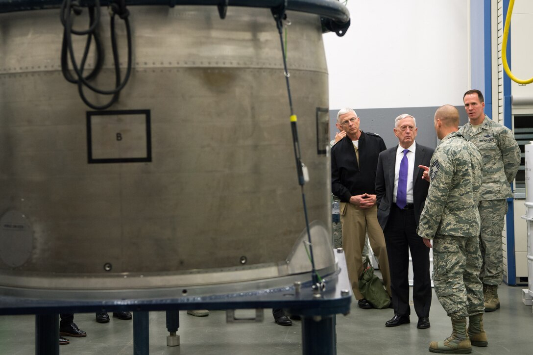 Defense Secretary Jim Mattis and several service members stand next to equipment at a missile facility.