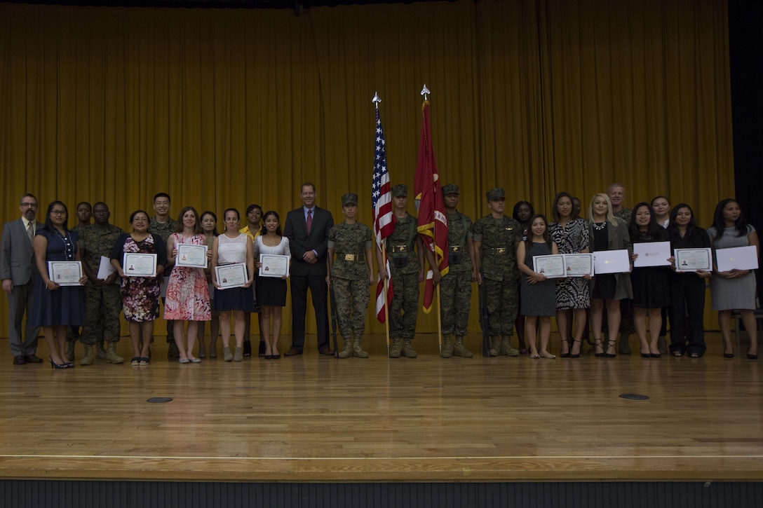 New U.S. citizens and leadership pose for a photo after a Naturalization Ceremony Sept. 13 in the base theater aboard Camp Foster, Okinawa, Japan.