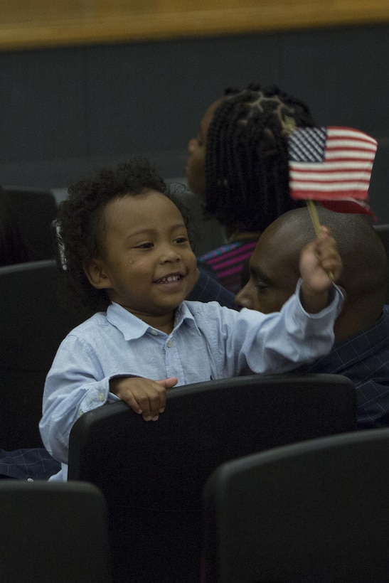 CAMP FOSTER, OKINAWA, Japan—A child waves an American flag during a Naturalization Ceremony Sept. 13 in the theater aboard Camp Foster, Okinawa, Japan.