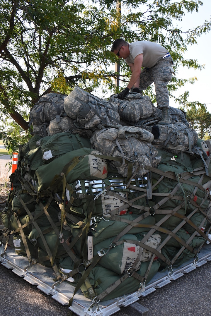 Wisconsin Air National Guard member is palletizing luggage for a flight to Florida.