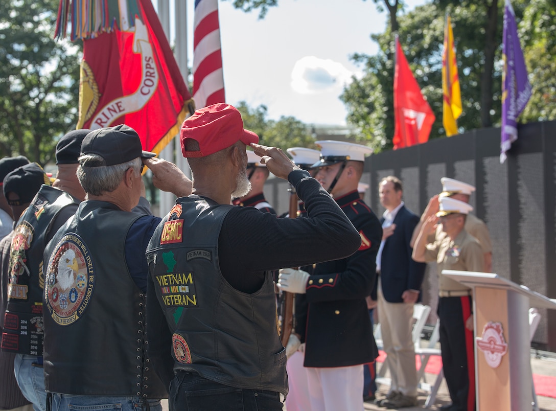 The U.S. Marine Corps Color Guard presents the National Ensign and the U.S. Marine Corps Battle Colors during a Vietnam War pinning ceremony as a part of Marine Week, Detroit, MI., Sept. 8, 2017. The Traveling Vietnam Memorial Wall was set up alongside the Detroit Riverwalk where ten Vietnam veterans received commemorative pins to honor their service and sacrifice to our country. (Official U.S. Marine Corps photo by Cpl. Robert Knapp/Released)