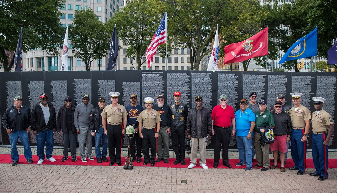 Marine Week Detroit leadership and Vietnam veterans pose for a picture in front of the Traveling Vietnam War Memorial at the conclusion of a Vietnam War pinning ceremony as a part of Marine Week, Detroit, MI., Sept. 8, 2017. The memorial was set up alongside the Detroit Riverwalk where ten Vietnam veterans received commemorative pins to honor their service and sacrifice to our country. (Official U.S. Marine Corps photo by Cpl. Robert Knapp/Released)