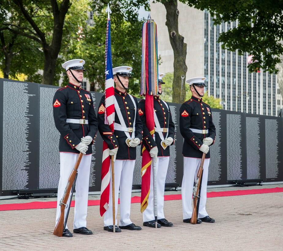 The U.S. Marine Corps Color Guard post at a ceremonial position alongside the Traveling Vietnam Memorial Wall after the conclusion of a Vietnam War pinning ceremony as a part of Marine Week, Detroit, MI., Sept. 8, 2017. The memorial was set up alongside the Detroit Riverwalk where ten Vietnam veterans received commemorative pins to honor their service and sacrifice to our country. (Official U.S. Marine Corps photo by Cpl. Robert Knapp/Released)