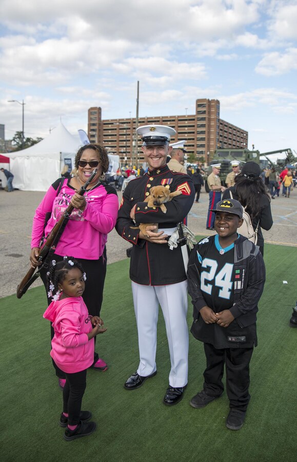 Corporal Christopher Vogt, marcher, U.S. Marine Corps Silent Drill Platoon, poses for a photo with Marine Week Detroit attendees following a performance at the static display section of Marine Week, Detroit, MI. Sept. 9, 2017. Marine Week, hosted by the Marine Corps in one city per year, is a celebration of community, country and Corps that allows the public to connect with Marines through live-demonstrations, hands-on static displays and several other interactive events. (Official U.S. Marine Corps photo by Cpl. Robert Knapp/Released)