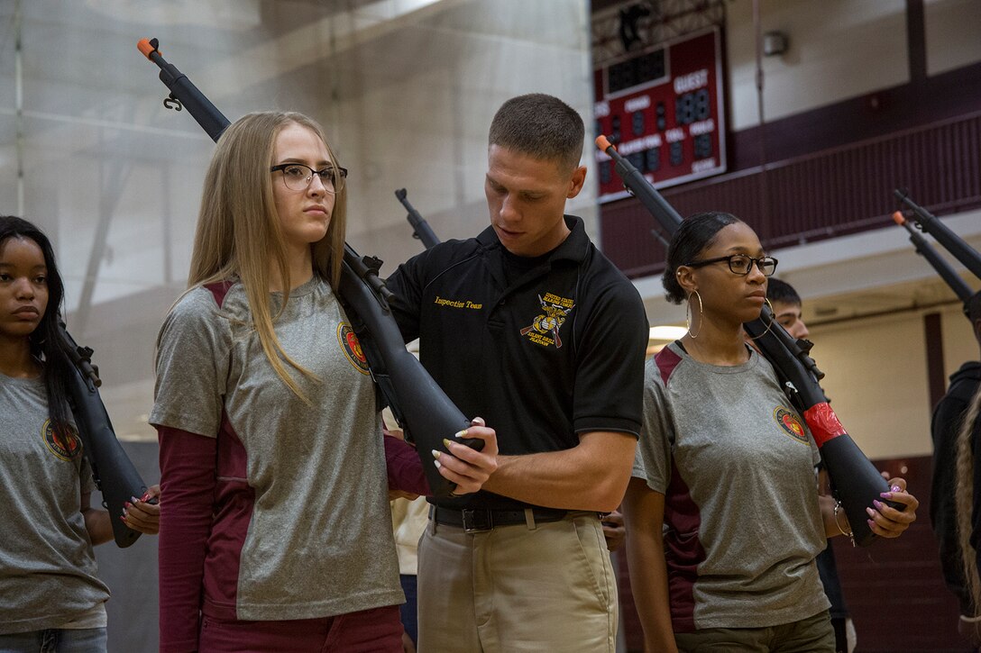 Lance Cpl. Daniel Linebaugh, rifle inspection team, U.S. Marine Corps Silent Drill Platoon, critiques a JROTC student’s drill techniques at River Rouge High School, River Rouge, MI., Sept. 6, 2017. In support of Marine Week Detroit, several Marines with the SDP inspection team traveled out to the high school to interact with the JROTC students and to assist with sharpening their rifle and drill maneuvers. (Official U.S. Marine Corps photo by Cpl. Robert Knapp/Released)