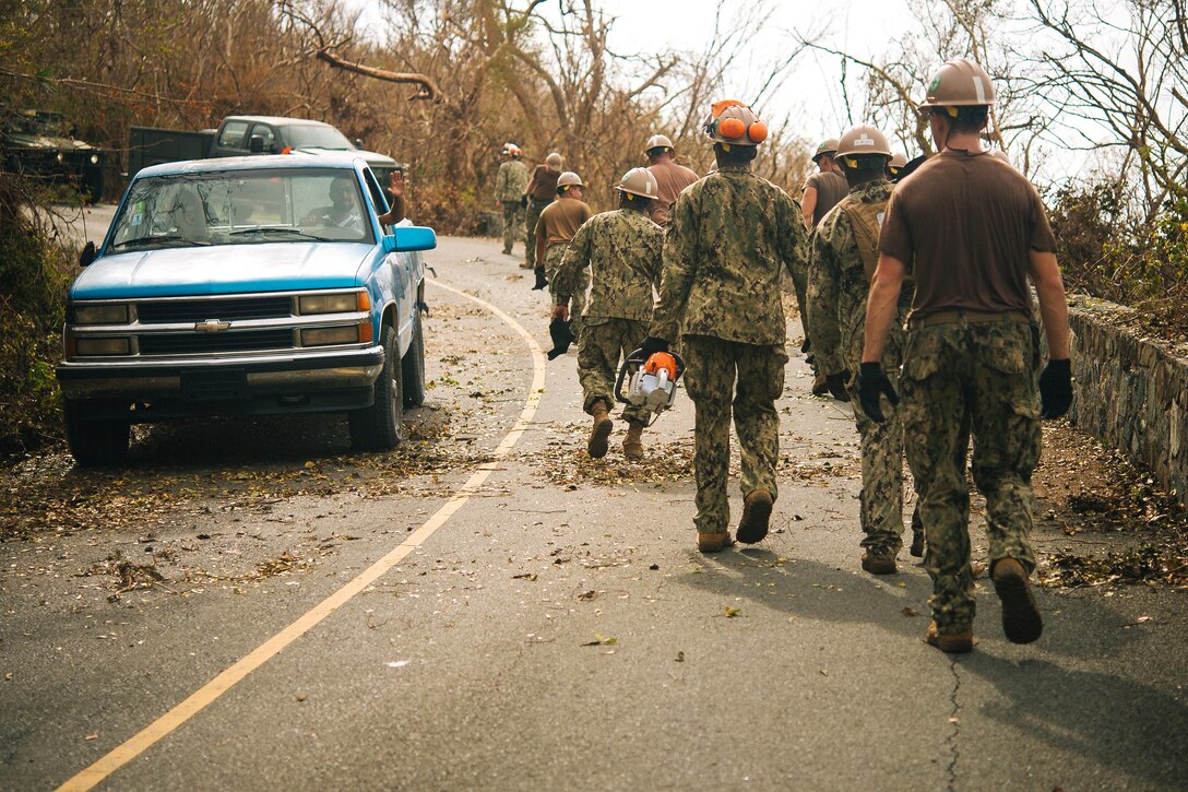 An islander in his truck thanks Seabees as they clear away debris.