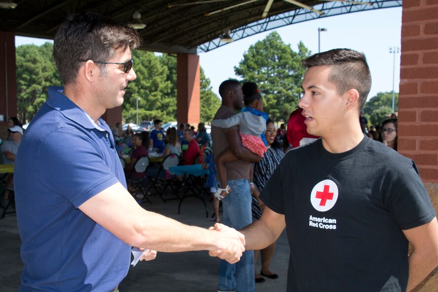 U.S. Air Force Reserve Col. Christopher T. Lay, commander, 913th Airlift Group, coins Airman 1st Class Clayton Quintana, client systems technician, 19th Communications squadron, during the group’s “Family Day” celebration at Little Rock Air Force Base, Ark., Sept. 10, 2017. Lay coined five 19th Airlift Wing Airmen for manning information festivity booths during the family day celebration, which is held to bring the families and members of the 913 AG closer together. (U.S. Air Force photo by Master. Sgt. Jeff Walston/Released)
