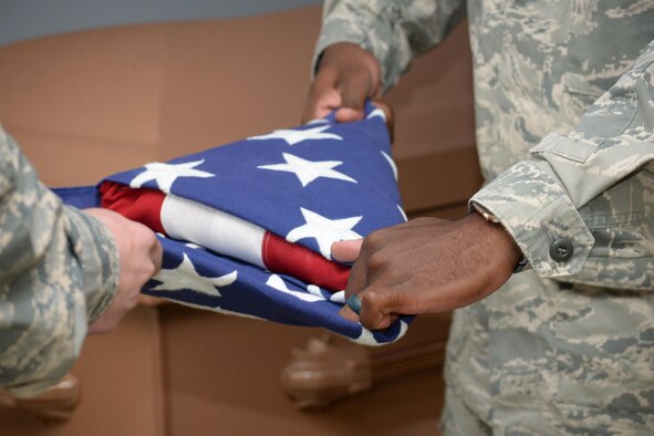 Columbus Air Force Base Honor Guardsmen practice folding the American flag into the traditional tri-fold Sept. 12, 2017, on Columbus Air Force Base, Mississippi. Guardsmen need to ensure the flag is folded neatly in order to present it to the family of a deceased veteran. (U.S. Air Force photo by Airman 1st Class Beaux Hebert)